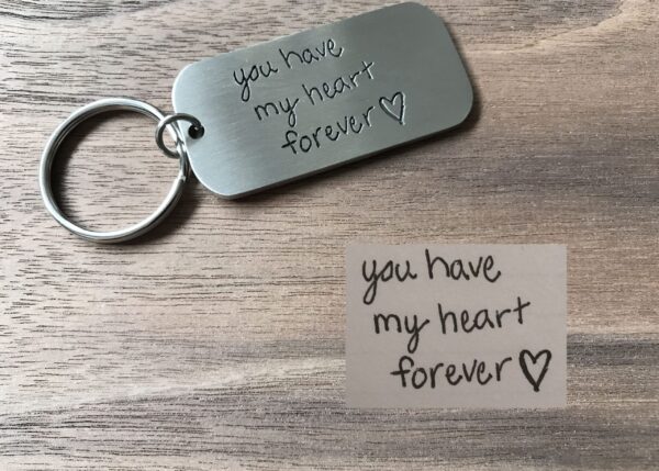 Engraved keychain with the message you have my heart forever on wooden background, ideal for romantic gifts.