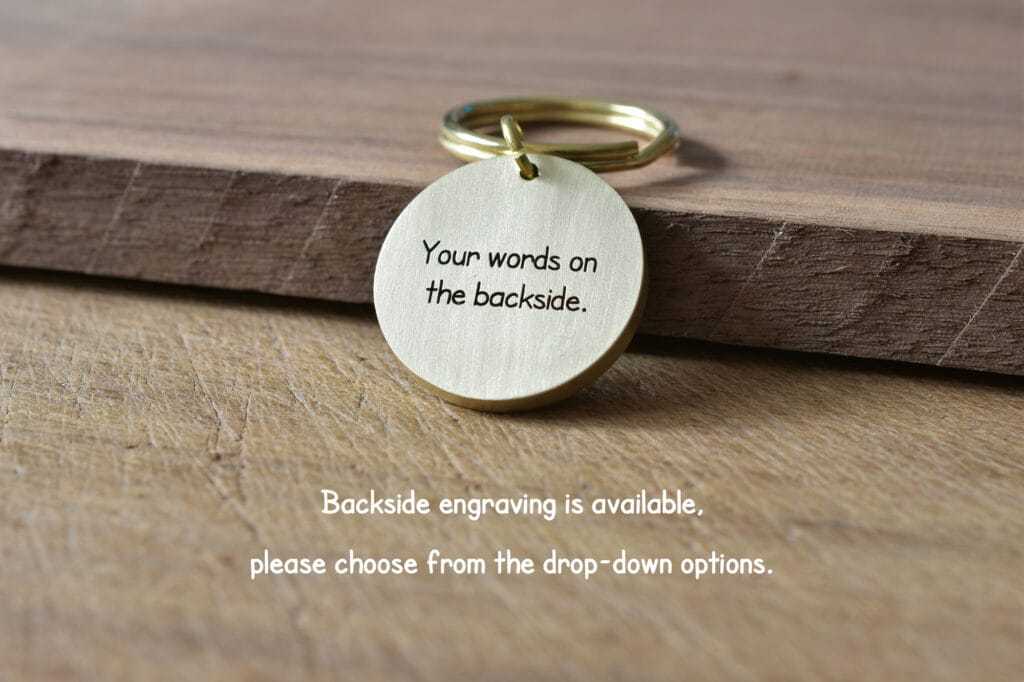 Engraved keychain on wooden surface offering customizable backside text options.