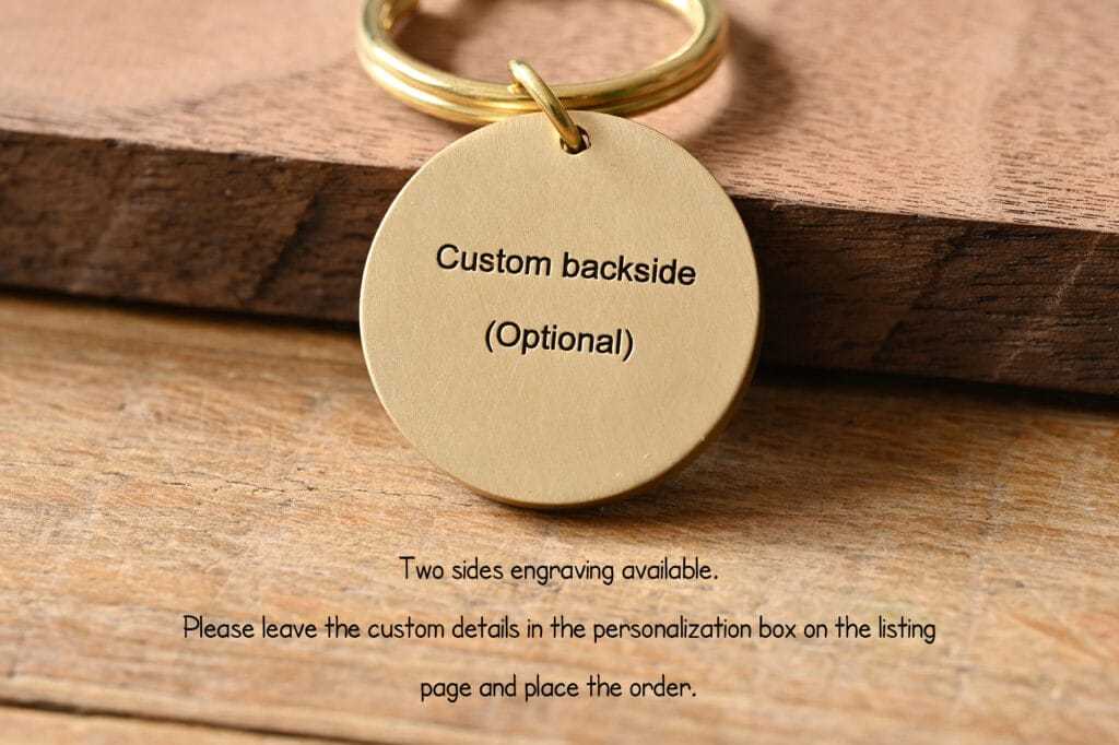 Gold keychain on wooden surface with customizable engraving option. Personalize your accessory today.