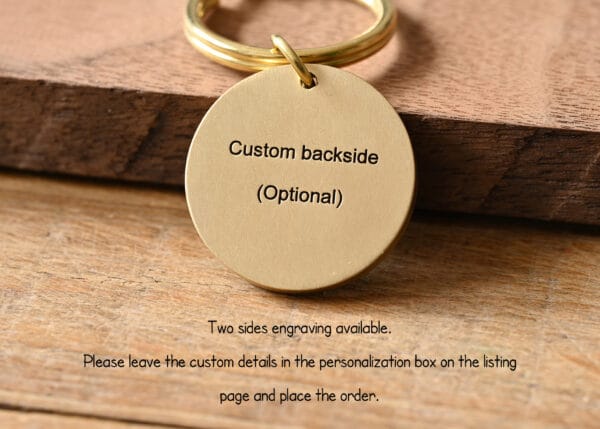 Gold keychain on wooden surface with customizable engraving option. Personalize your accessory today.
