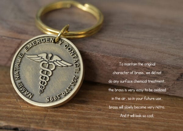 Brass emergency contact keychain with Caduceus symbol, highlighting natural oxidation and vintage appeal.