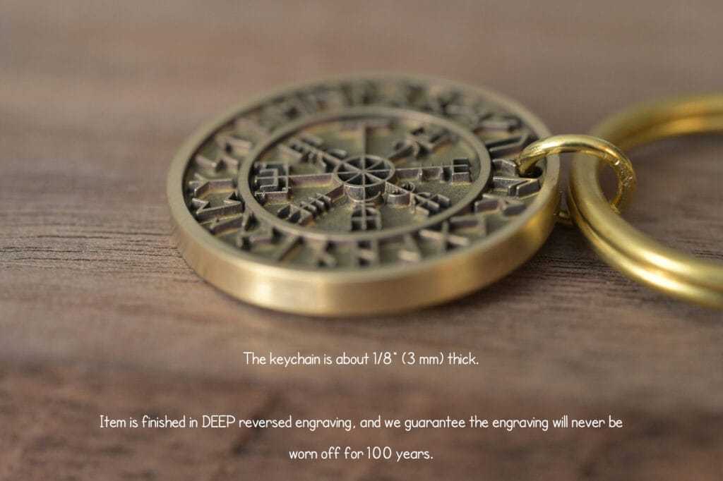 Close-up of intricately engraved brass keychain on wooden surface, 3mm thick, boasting durable 100-year-lasting design.