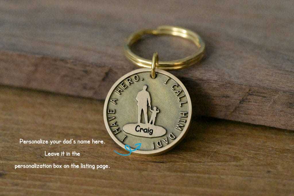 Gold keychain with engraved text I have a hero. I call him Dad, featuring a customizable name. Perfect Father's Day gift.