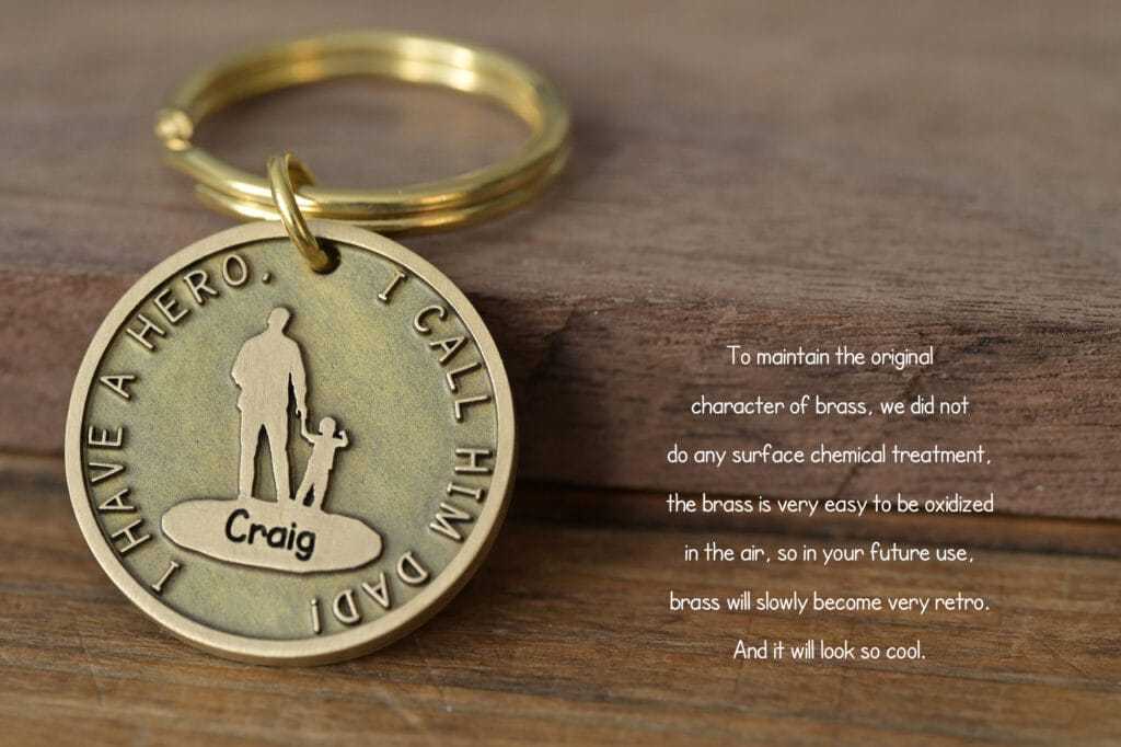 Brass keychain with I Have a Hero, I Call Him Dad engraved, features father and child silhouette.