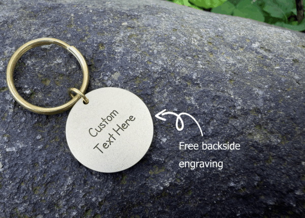 Customizable keychain on stone surface with free backside engraving text shown in white.