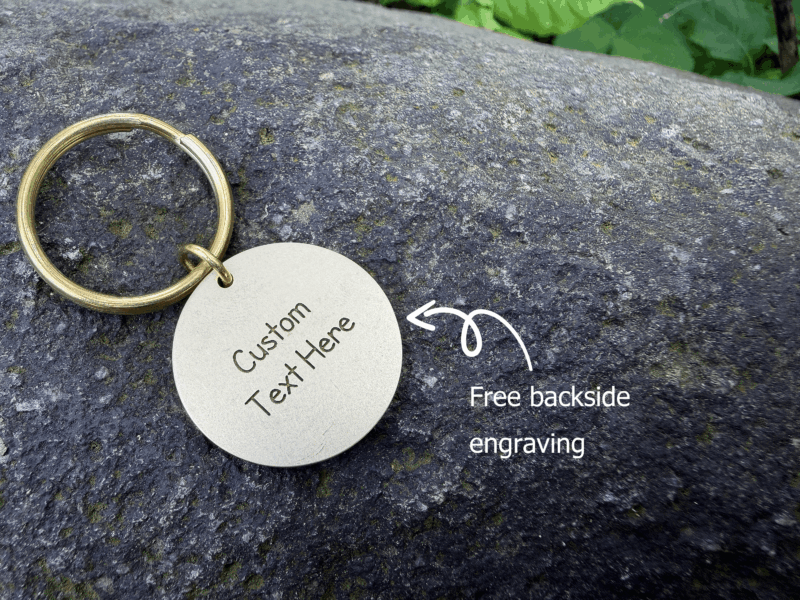 Customizable keychain on stone surface with free backside engraving text shown in white.