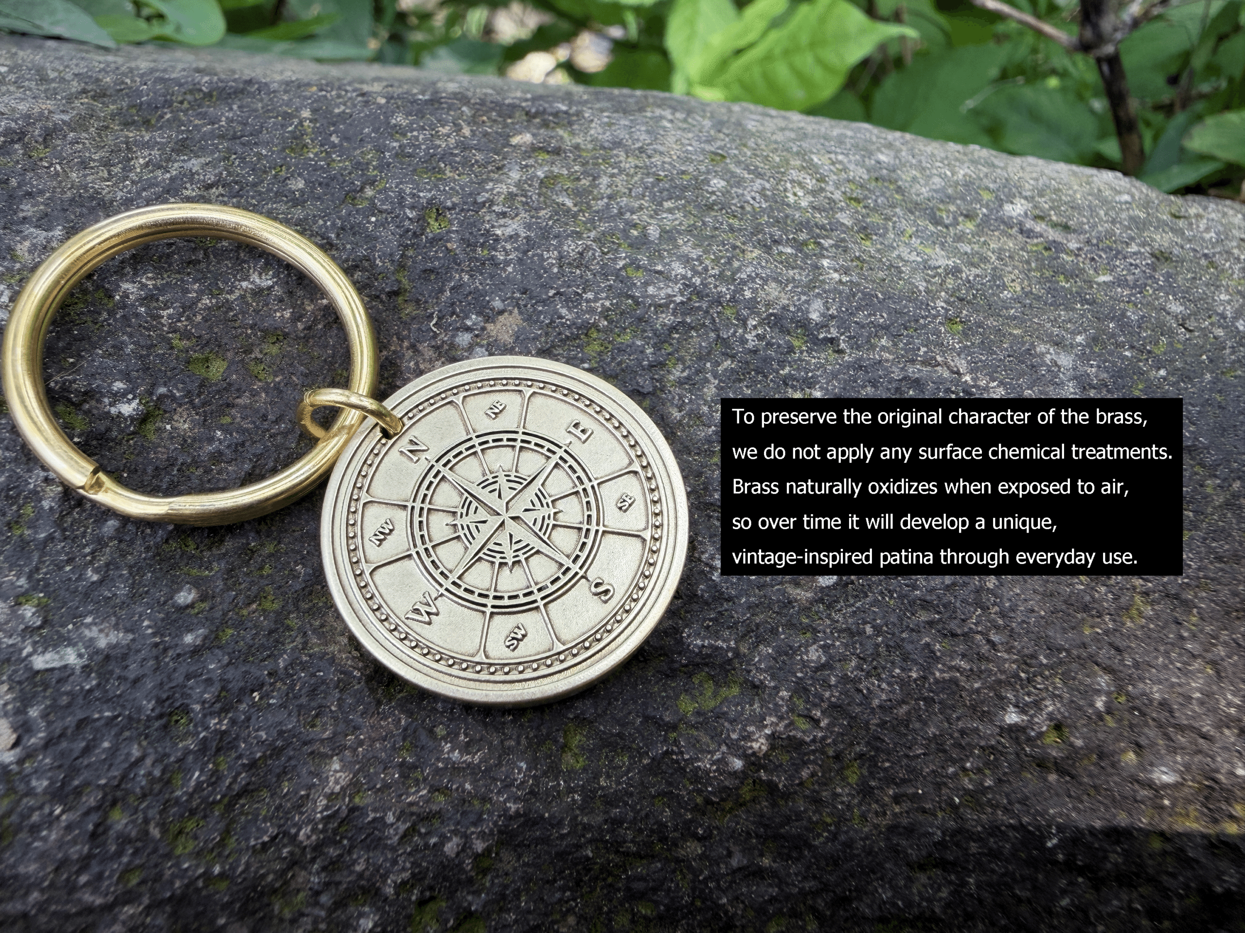 Brass keychain with compass engraving on stone background, showcasing natural patina preservation care text.