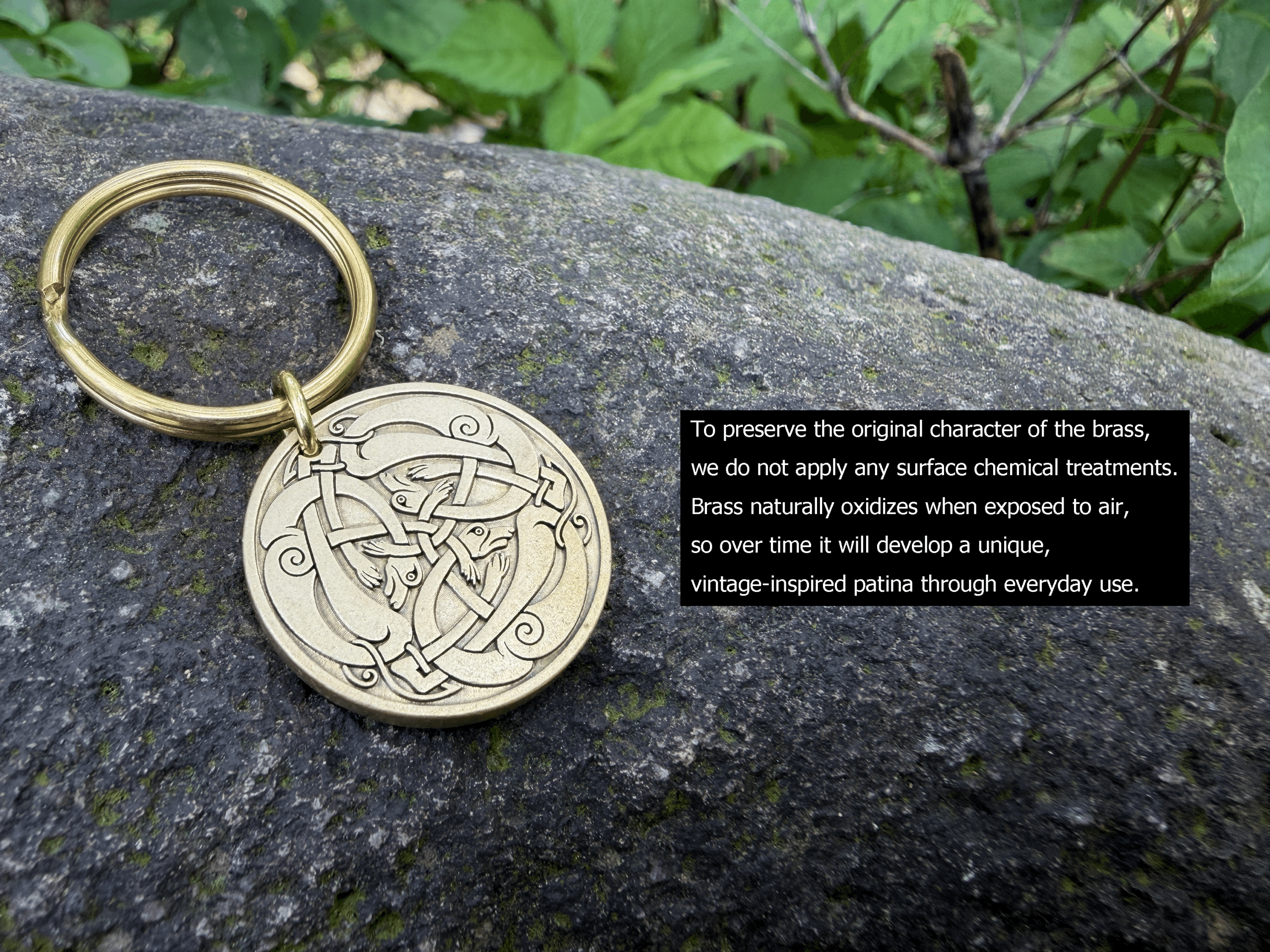 Brass keyring with intricate Celtic knot engraving, resting on a rock for a natural aesthetic background.