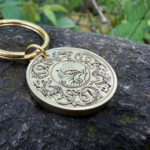 Engraved Norse longship keychain on stone, detailed boat and Viking design. Perfect for history lovers.