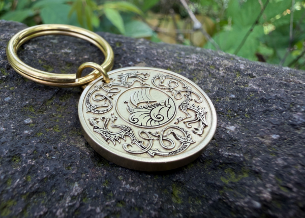 Engraved Norse longship keychain on stone, detailed boat and Viking design. Perfect for history lovers.