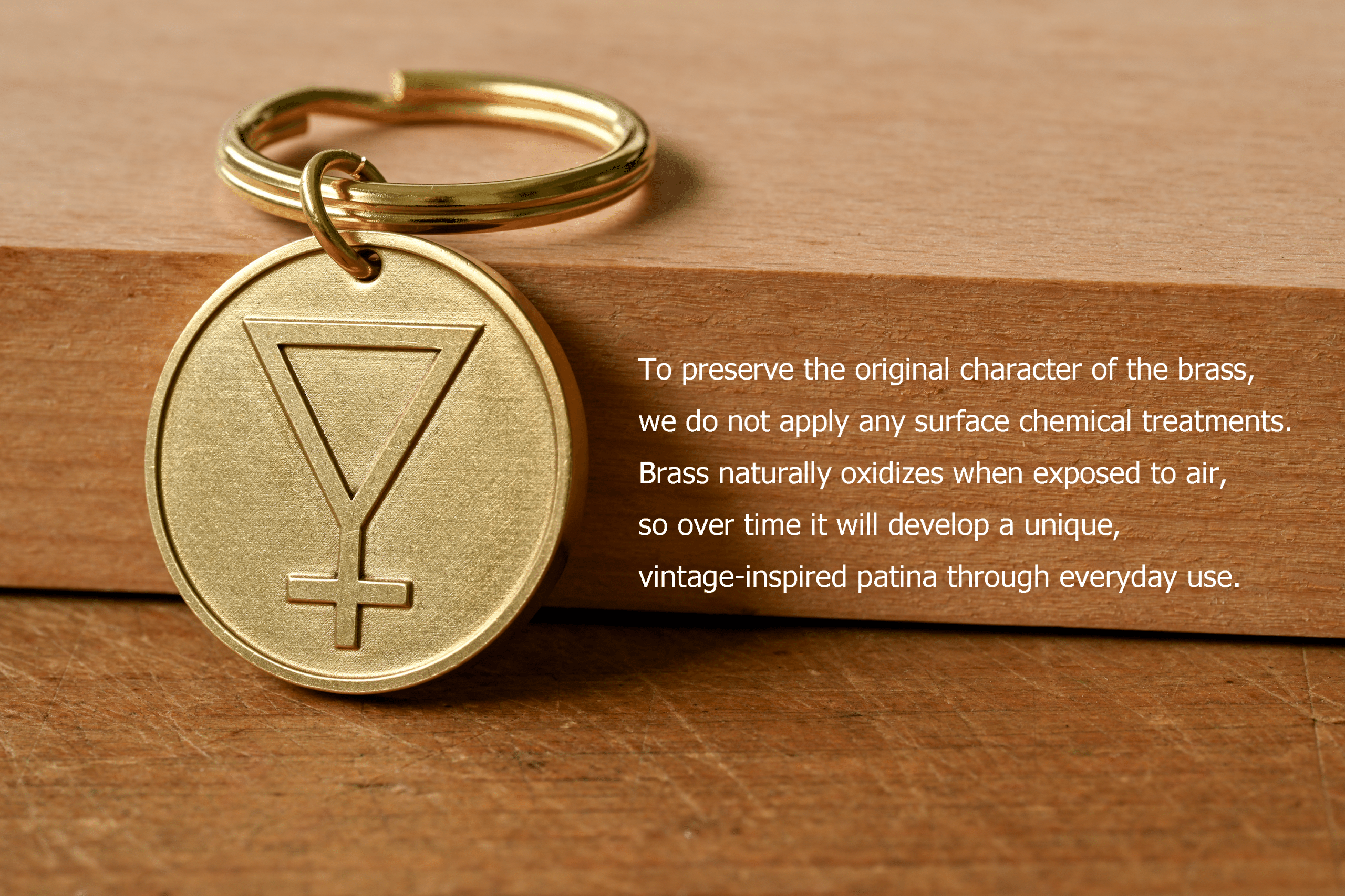Brass keychain with an engraved symbol beside text: To preserve the original character of the brass, we do not apply any surface chemical treatments. Brass naturally oxidizes when exposed to air, so over time it will develop a unique, vintage-inspired patina through everyday use