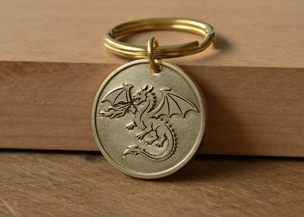 Brass circular keychain tag engraved with a fire-breathing dragon design