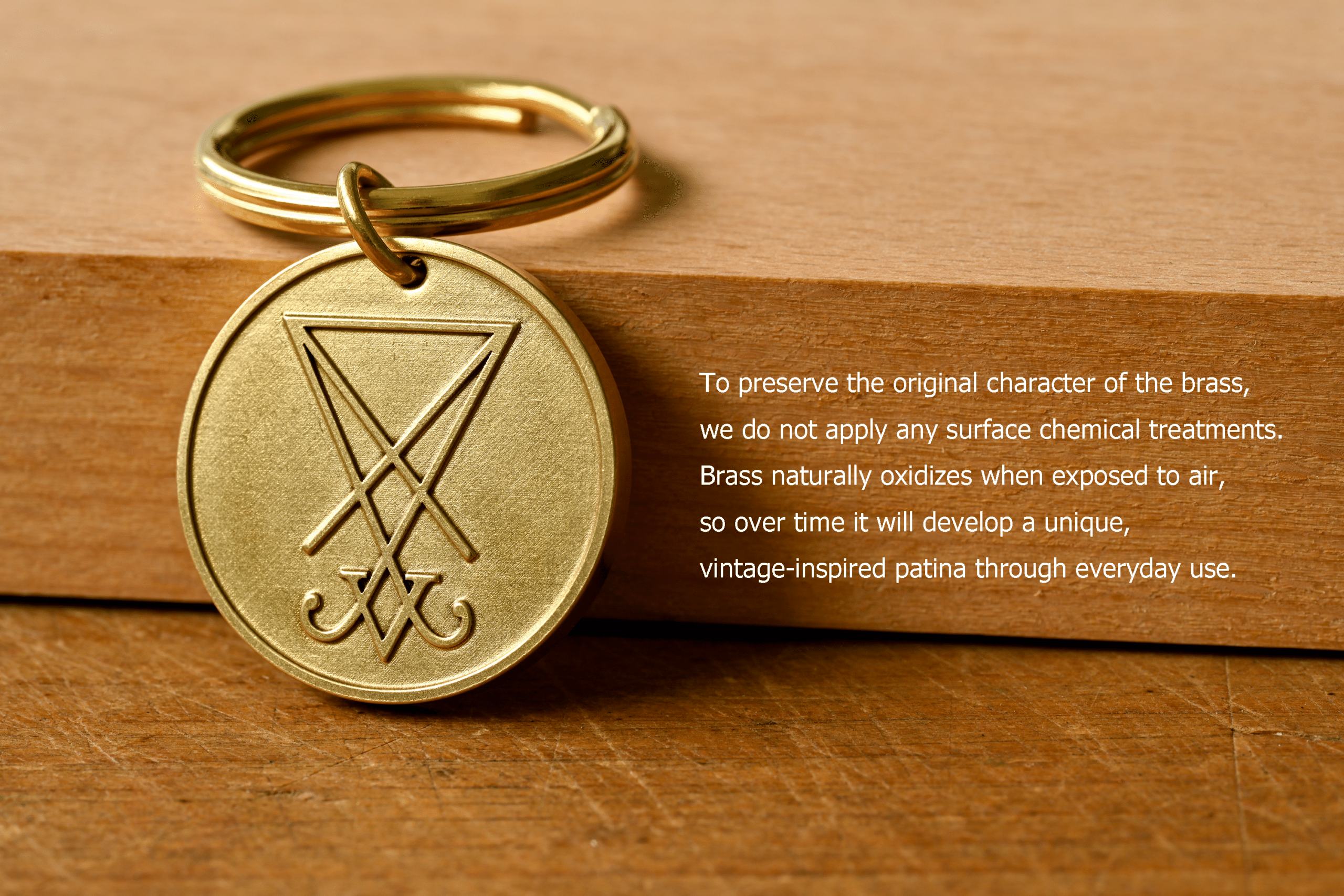 Brass key ring tag engraved with the Sigil of Lucifer. Text reads: To preserve the original character of the brass, we do not apply any surface chemical treatments. Brass naturally oxidizes when exposed to air, so over time it will develop a unique, vintage-inspired patina through everyday use