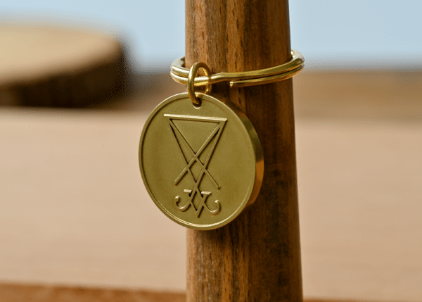Gold keychain featuring a round medallion engraved with the Sigil of Lucifer