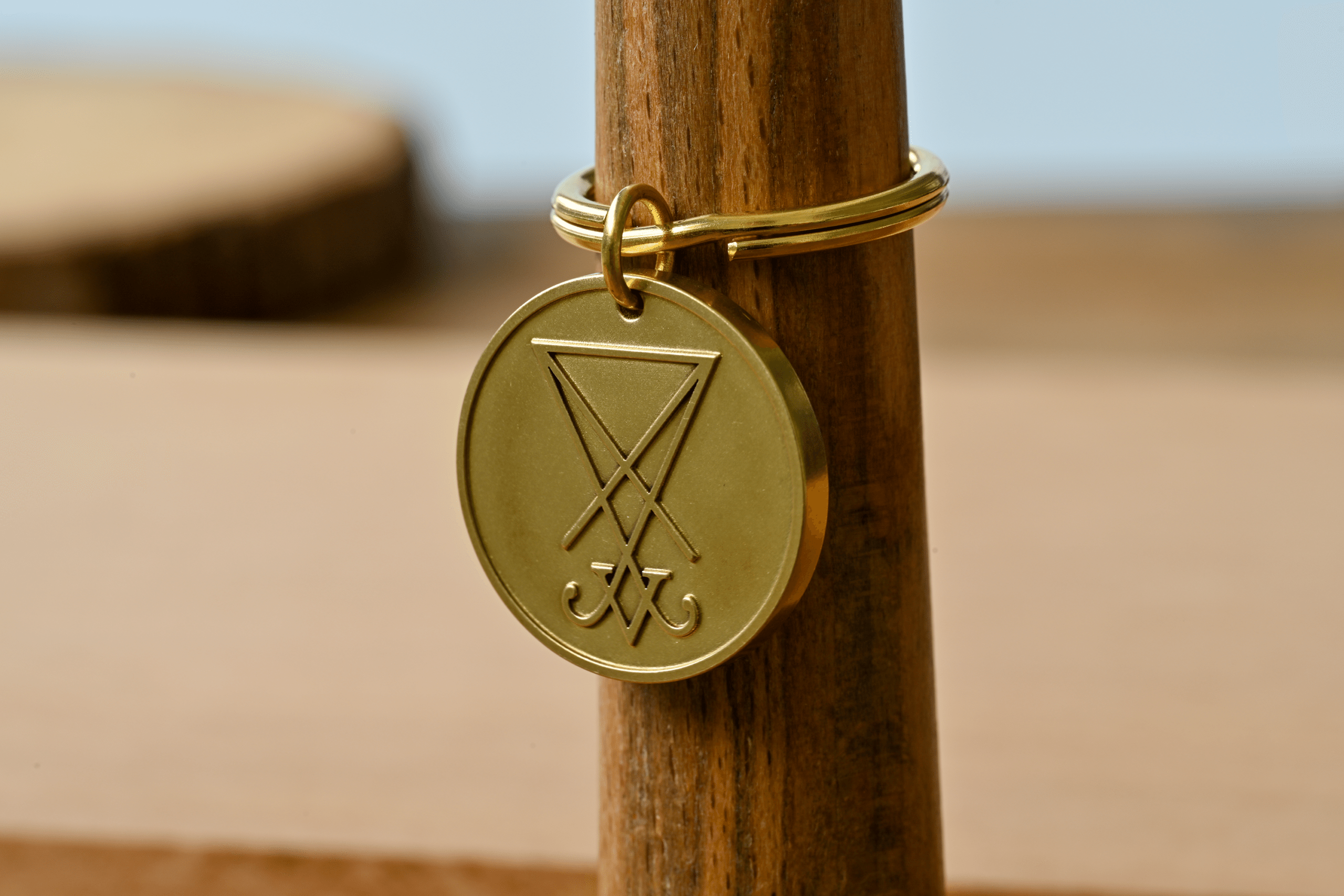 Gold keychain featuring a round medallion engraved with the Sigil of Lucifer