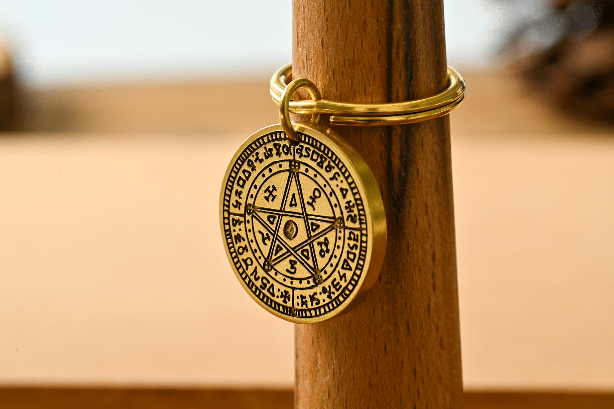 Brass keychain medallion engraved with a pentagram and mystical symbols