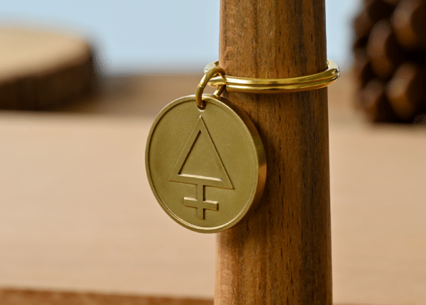 Brass keychain with a circular pendant engraved with the alchemical symbol for sulfur