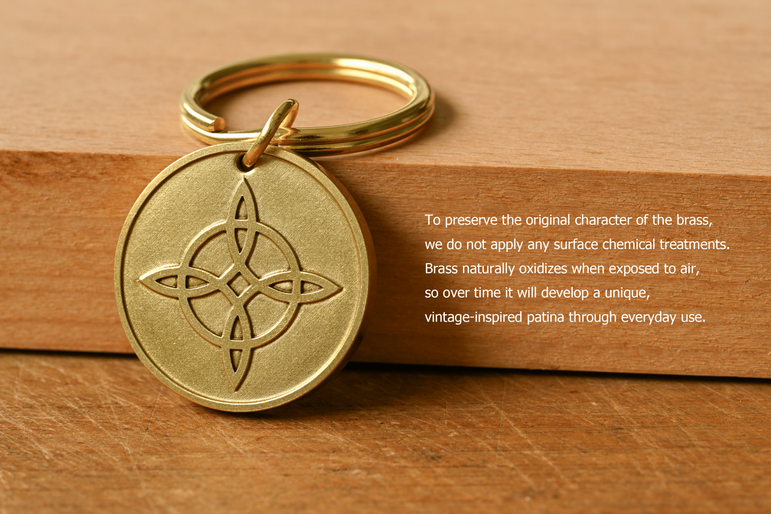 Brass keychain tag with a Celtic knot design next to text: To preserve the original character of the brass, we do not apply any surface chemical treatments. Brass naturally oxidizes when exposed to air, so over time it will develop a unique, vintage-inspired patina through everyday use