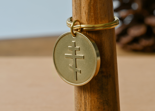 Round brass keychain medallion engraved with an Eastern Orthodox cross