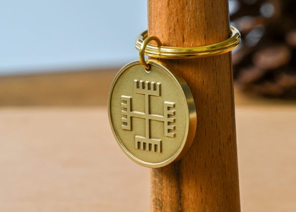 Brass circular keychain pendant engraved with a Slavic Hands of God cross symbol