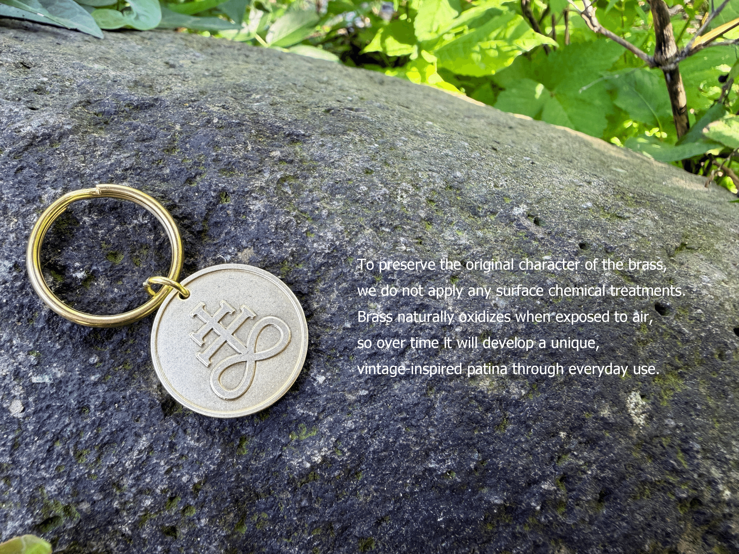 Brass keychain with an engraved symbol resting on a rock. To preserve the original character of the brass, we do not apply any surface chemical treatments. Brass naturally oxidizes when exposed to air, so over time it will develop a unique, vintage-inspired patina through everyday use