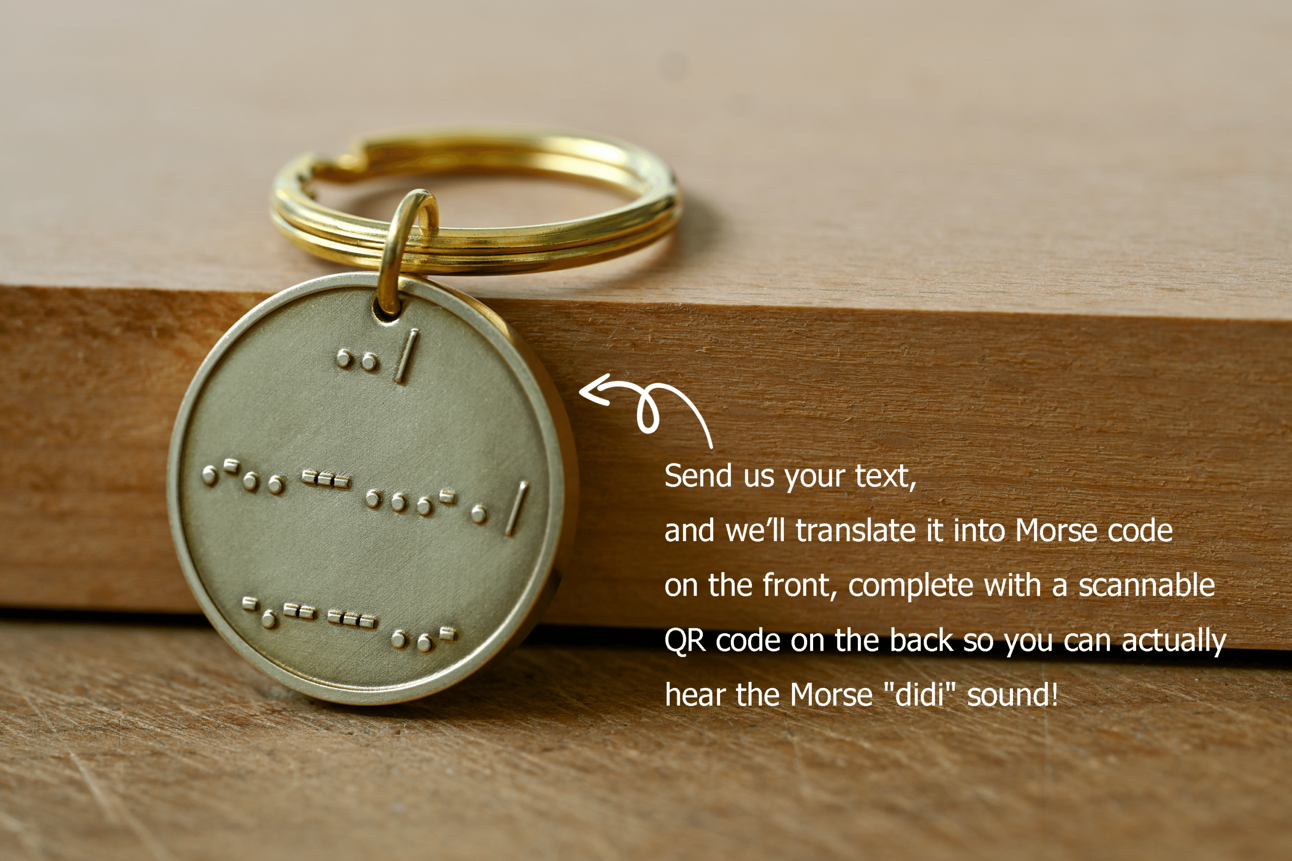 Brass key tag embossed with raised Morse code. Text reads: Send us your text, and we’ll translate it into Morse code on the front, complete with a scannable QR code on the back so you can actually hear the Morse didi sound!