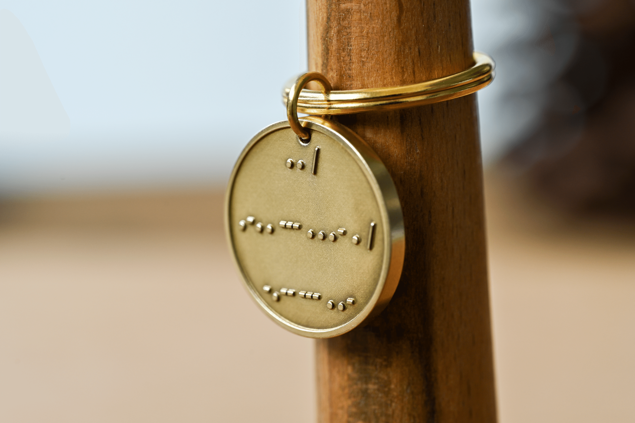 Circular brass keychain tag engraved with Morse code spelling I love you