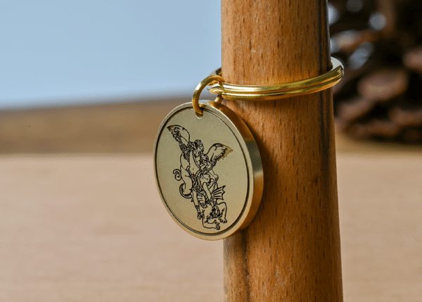 Gold key ring with a round pendant engraved with Archangel Michael slaying a dragon