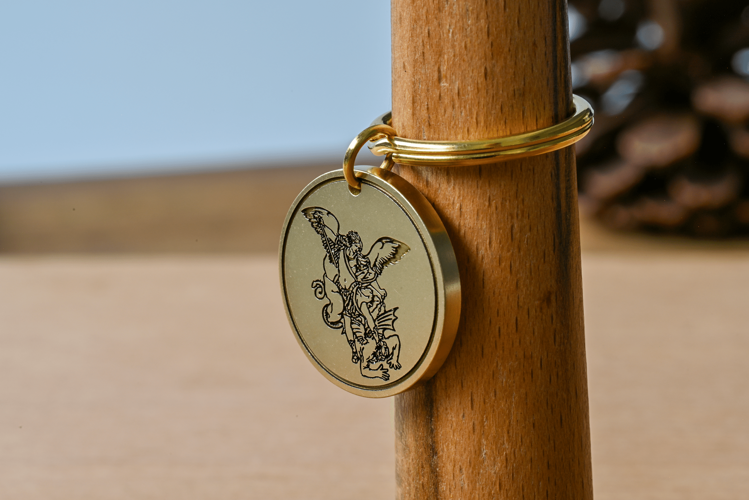 Gold key ring with a round pendant engraved with Archangel Michael slaying a dragon