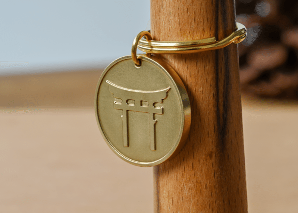Brass keychain tag engraved with a Japanese torii gate design
