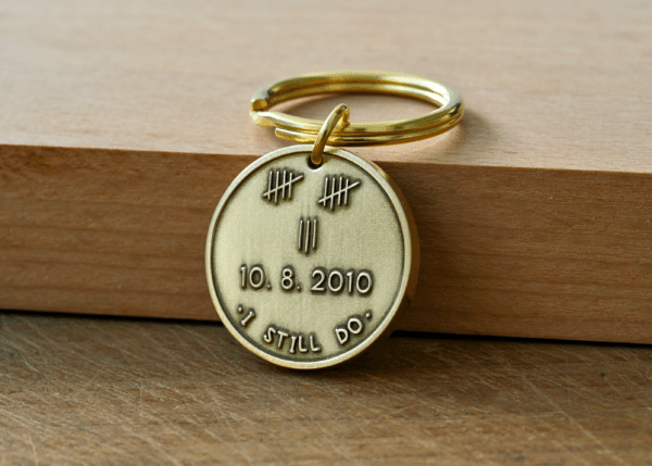 Brass keychain tag engraved with 13 tally marks, the date 10.8.2010, and the phrase I STILL DO
