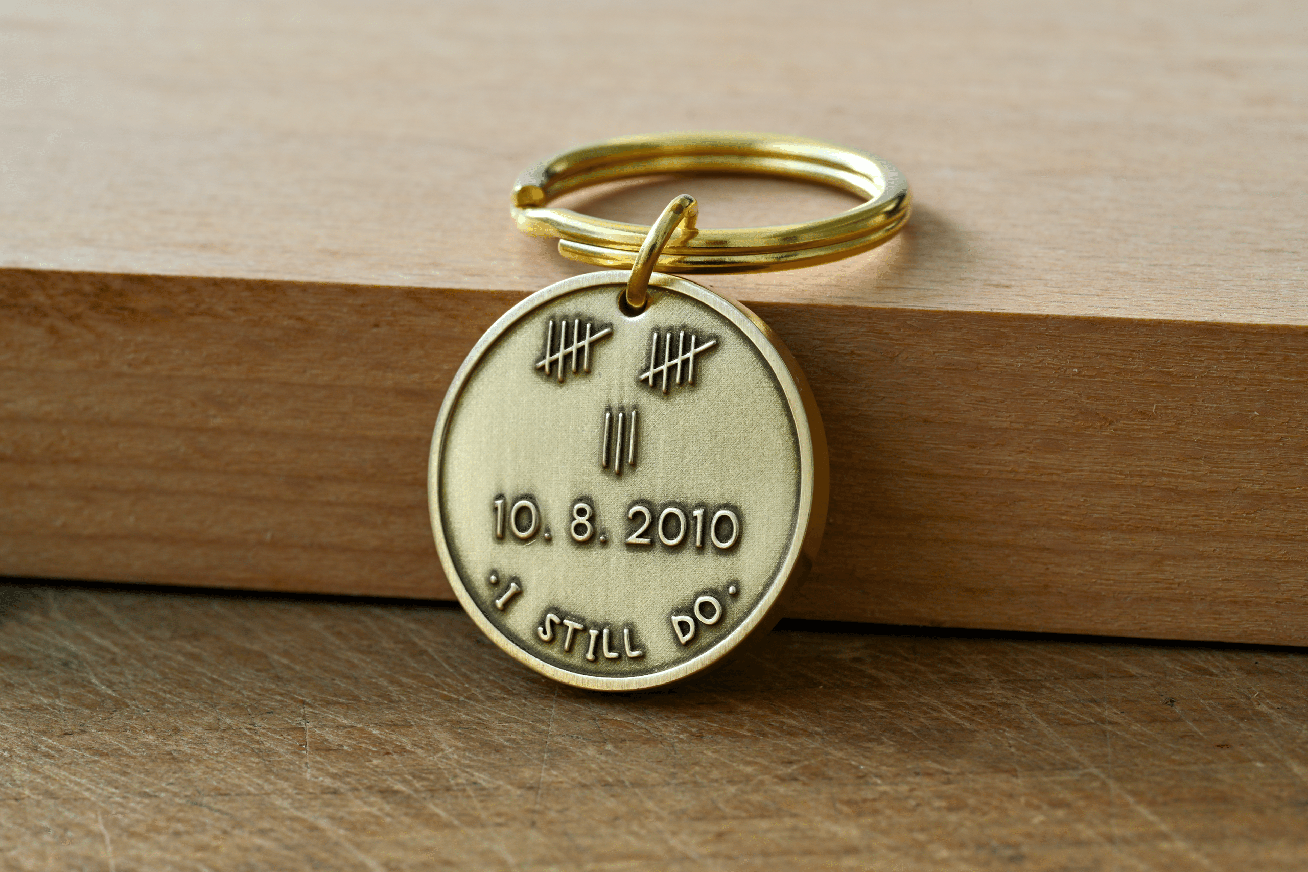 Brass keychain tag engraved with 13 tally marks, the date 10.8.2010, and the phrase I STILL DO