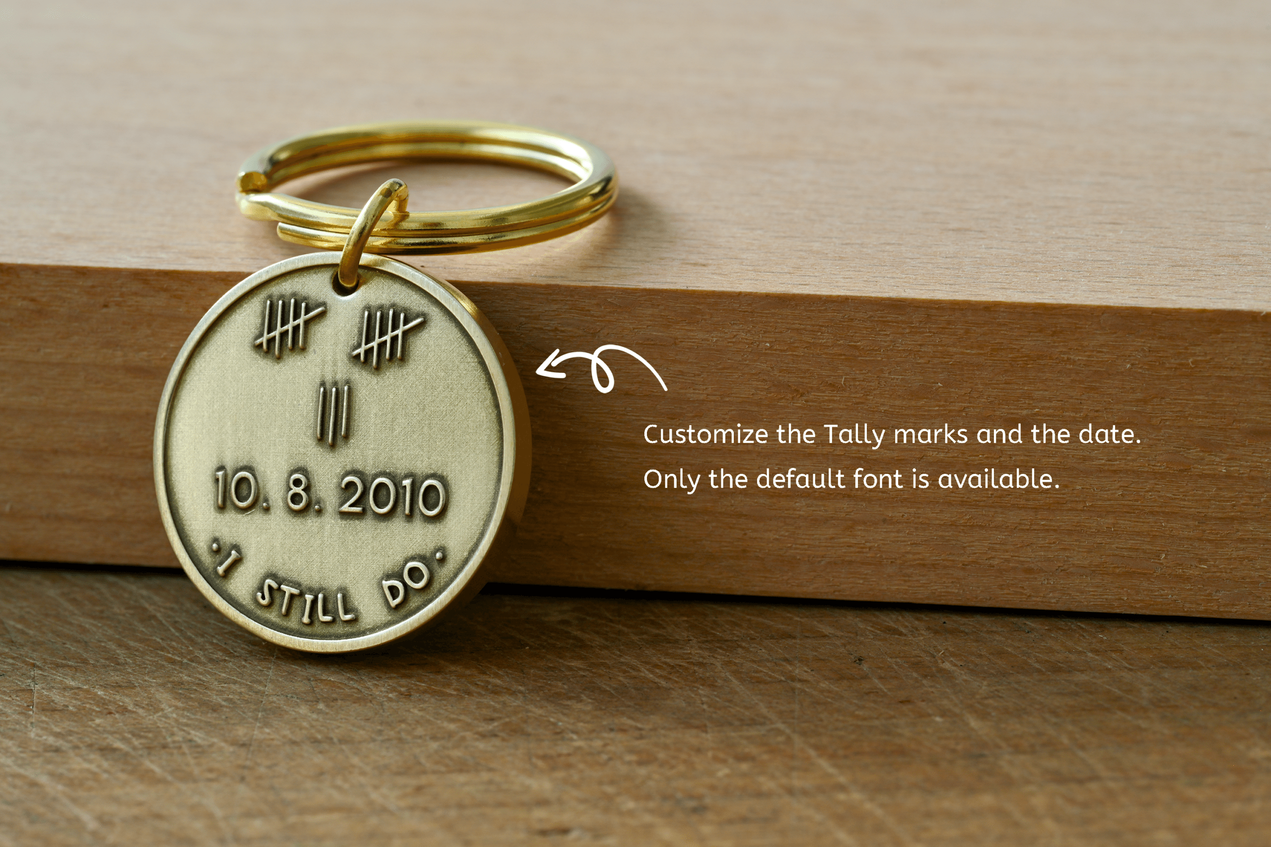 Customizable brass keychain stamped with tally marks, date 10.8.2010, and I STILL DO, with overlay text noting tally marks and date can be customized