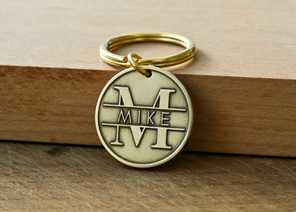 Round brass keychain tag engraved with a large monogram letter M and the name Mike